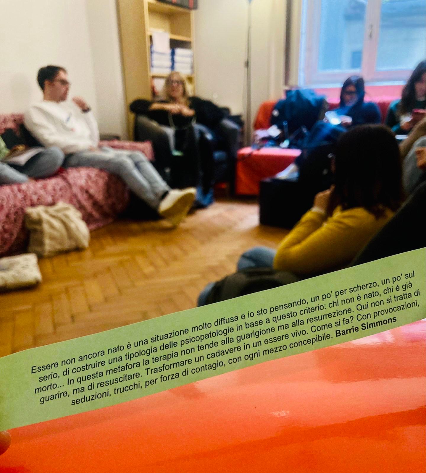 Gruppo di allievi seduti a terra e sui divani in discussione nel salone della sede CSTG di Milano